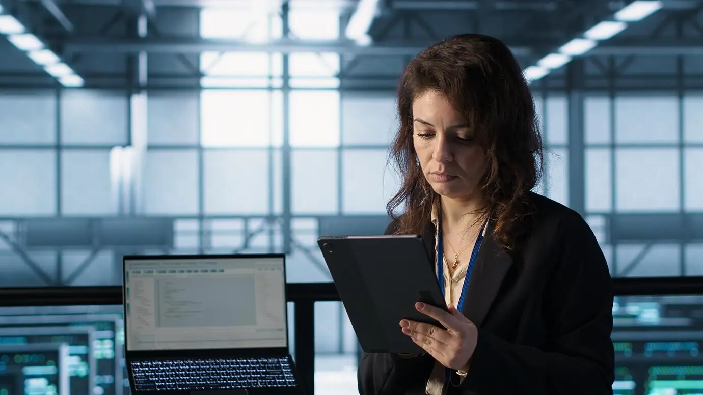 Администратор в центре обработки данных использует технологии искусственного интеллекта на планшете.